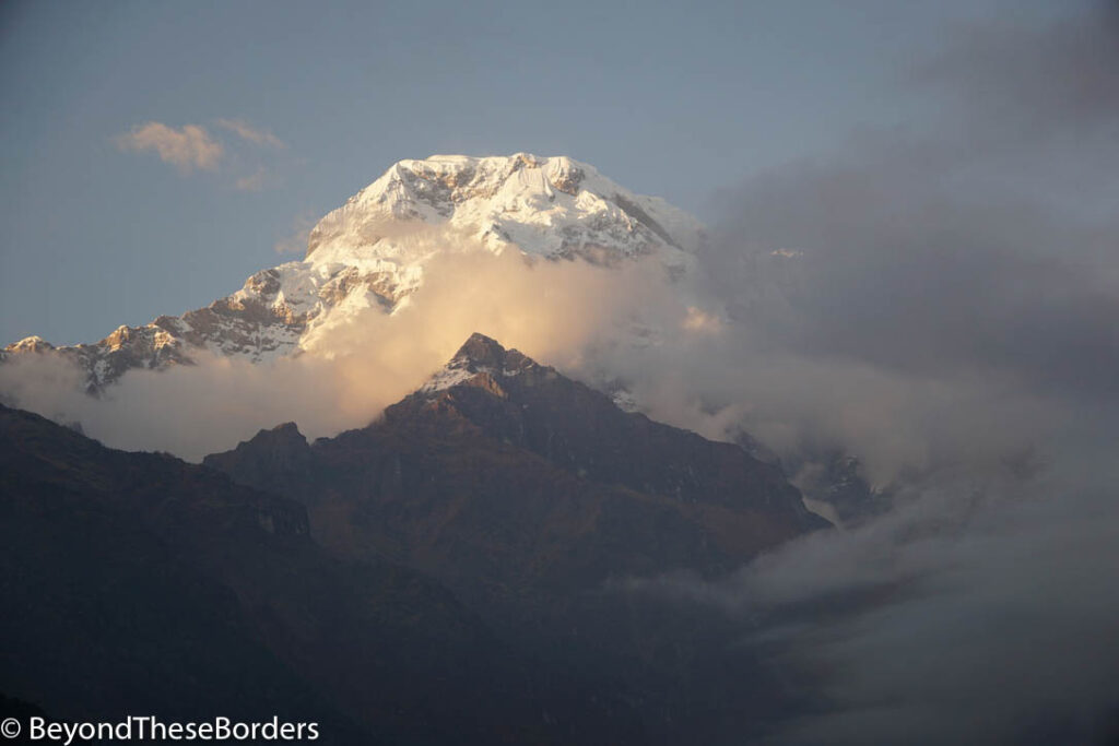 A glimpse of the top of a snowy mountaintop as the clouds briefly open up.