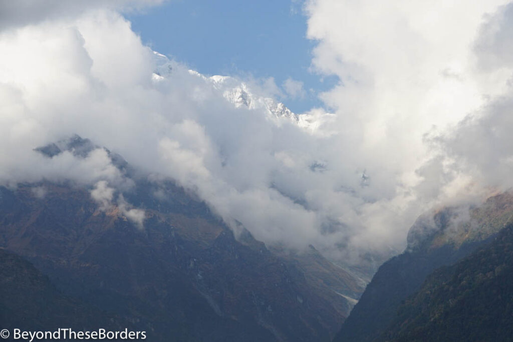 The mountains barely visible behind all the clouds drifting by.