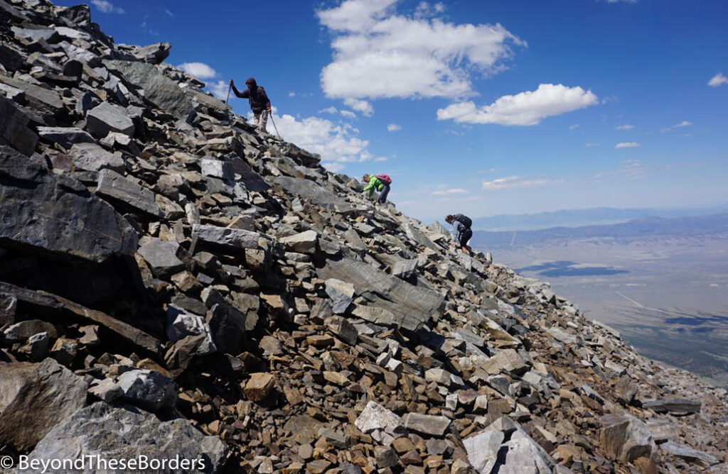 3 hikers climbing the 40 degree rocky ascent.