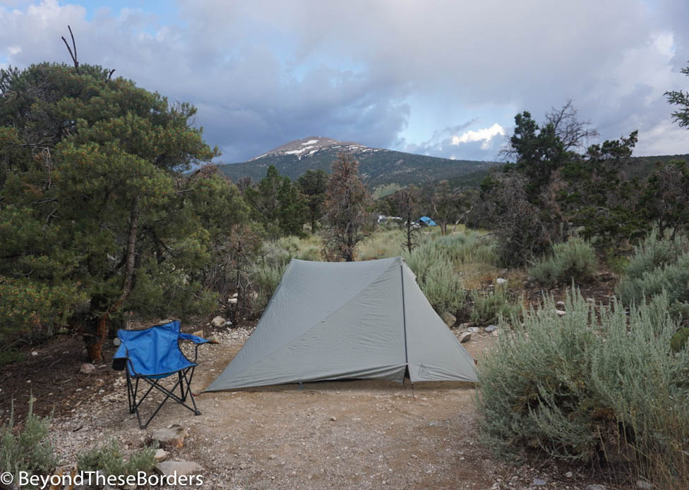 Our tent in a desert brush landscape.  The peak of a mountain far off in the distance.